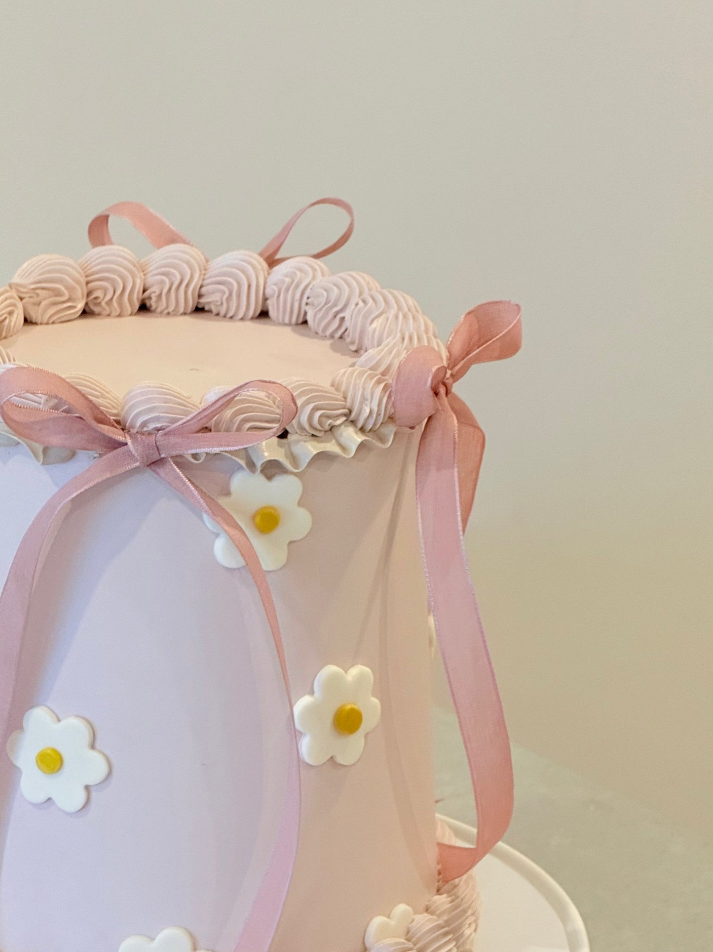 Decorative headband with pink ribbons and white flowers on a light background