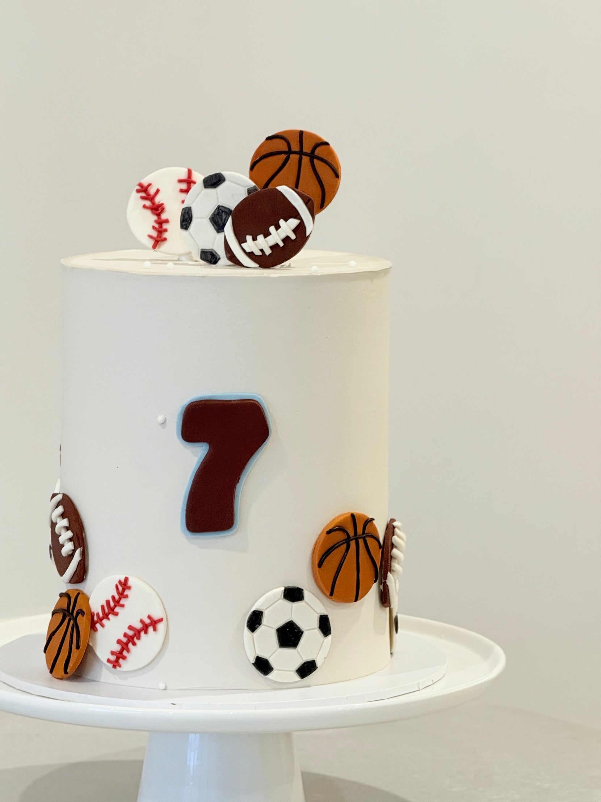 White cake with sports-themed decorations on a white background