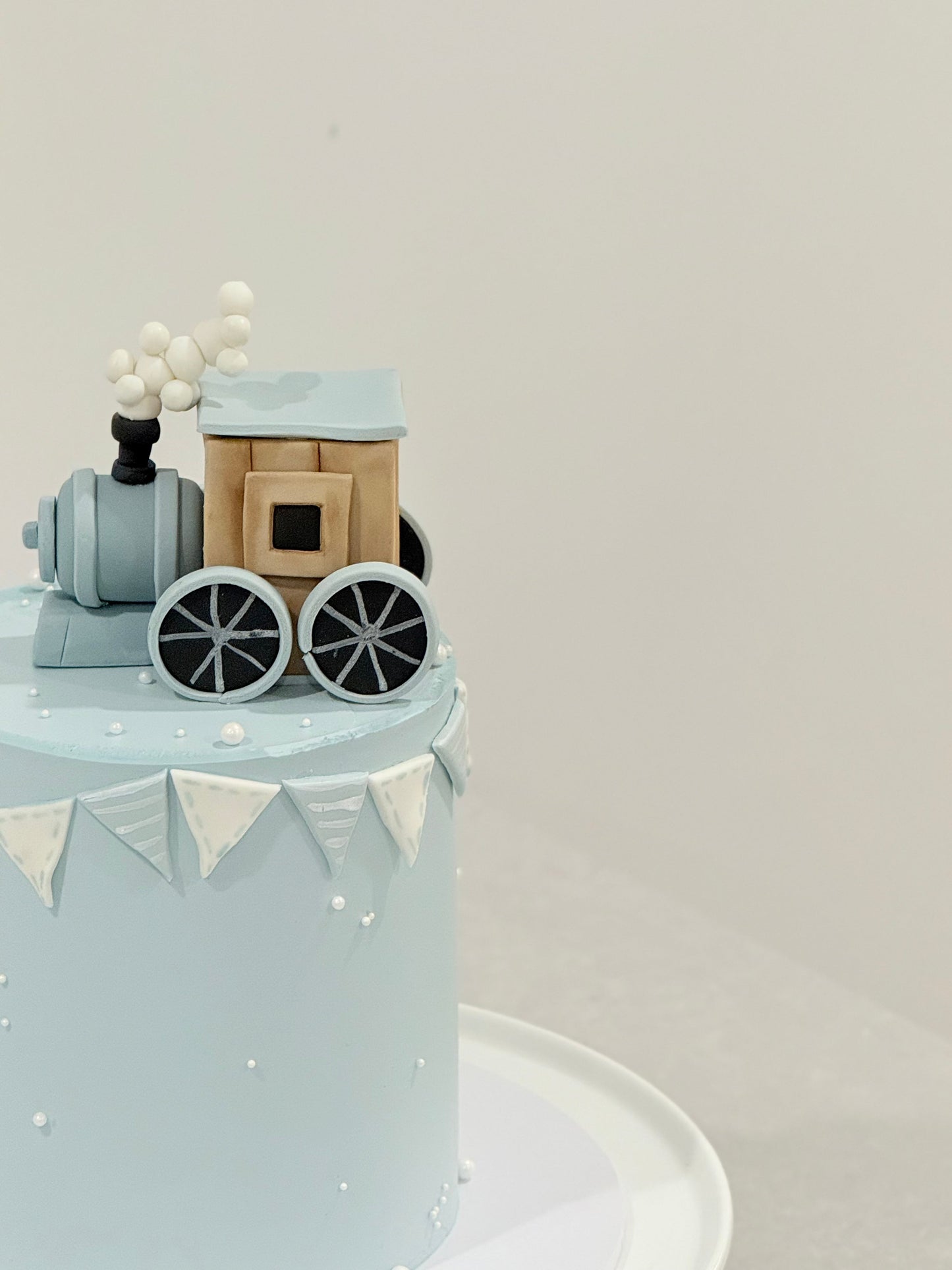 Small train model on a cake with a plain background