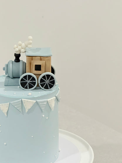 Small train model on a cake with a plain background
