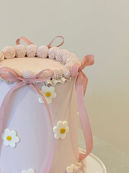 Decorative headband with pink ribbons and white flowers on a light background