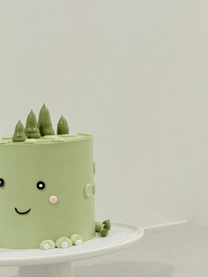 Sage green dino kids birthday cake with buttercream pine trees — custom handcrafted Melbourne