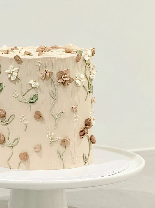 Elodie floral cake top view — scattered 3D blooms and sage leaf sprigs — Bakeology Studios Melbourne
