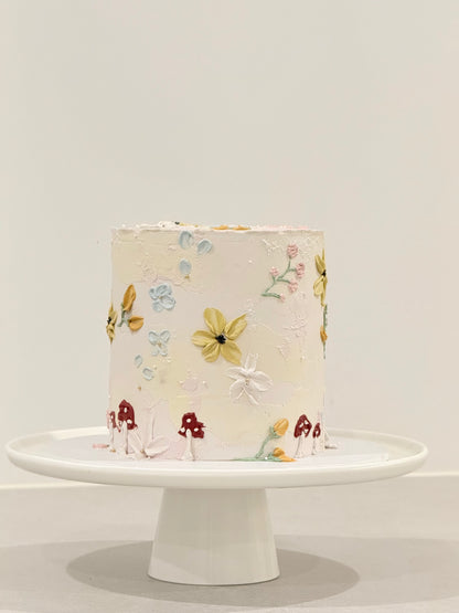 Decorative cake with floral patterns on a white stand against a light gray background