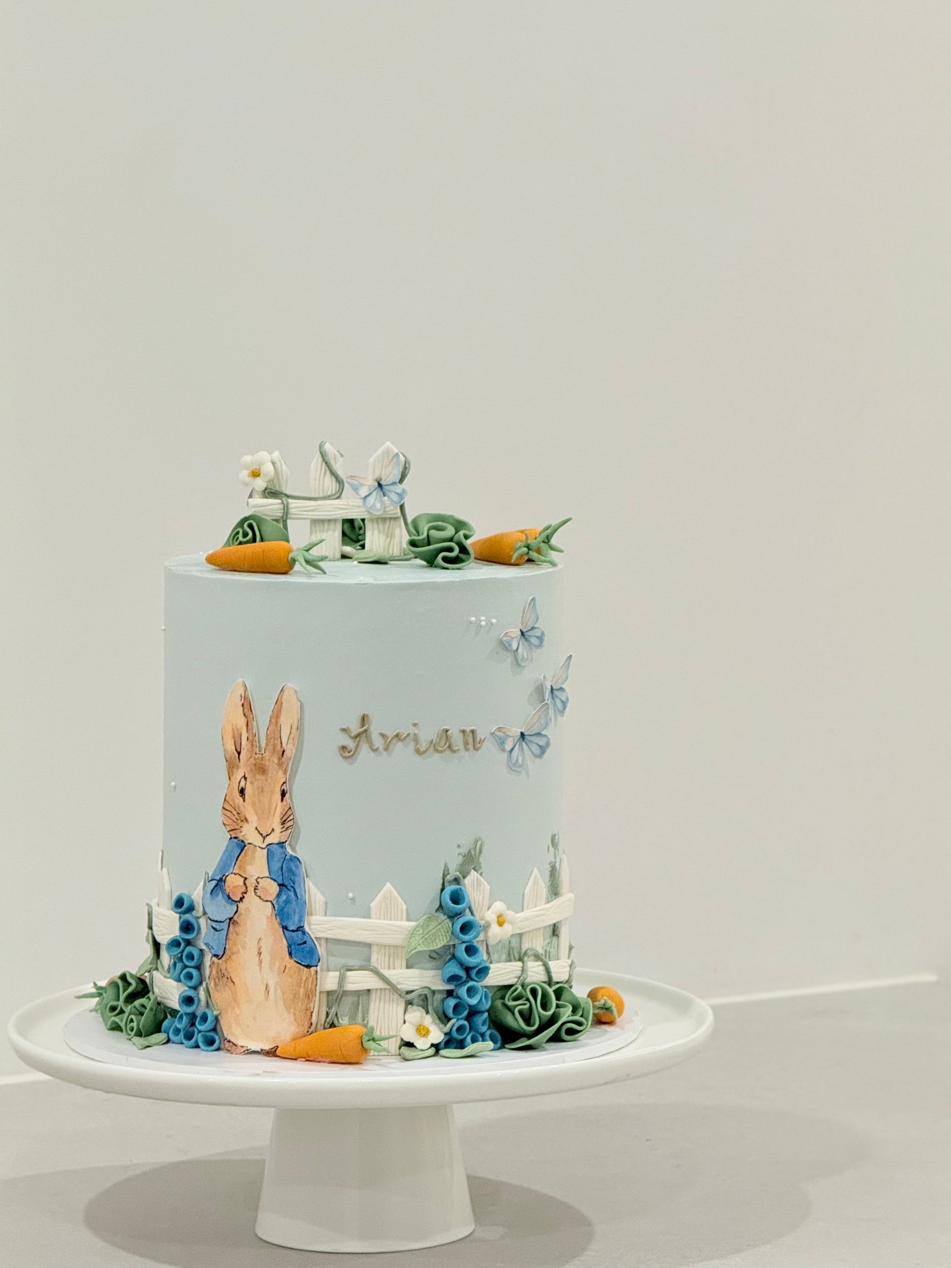 Peter Rabbit birthday cake top view — carrots butterflies and garden details — Bakeology Studios Melbourne