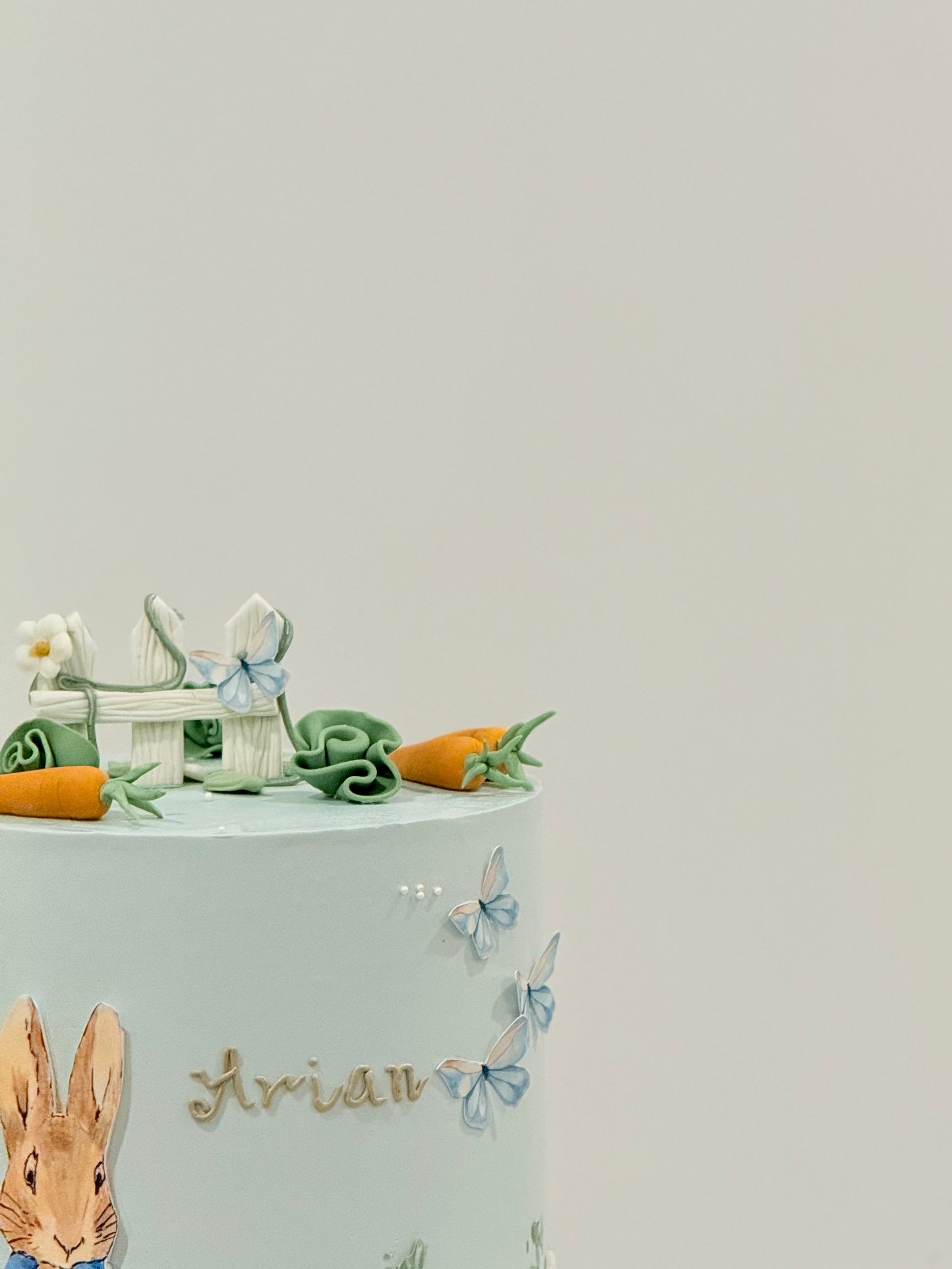 Peter Rabbit garden scene cake close-up — picket fence florals and carrots — Bakeology Studios Melbourne