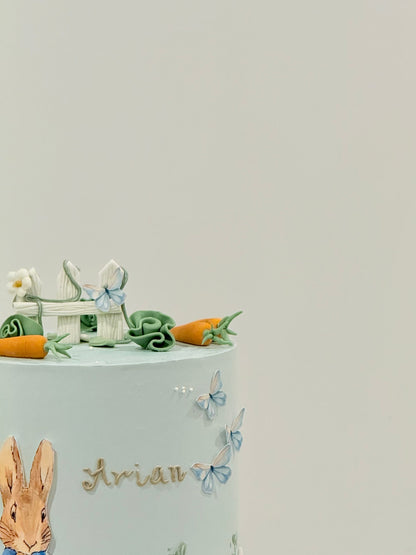 Peter Rabbit garden scene cake close-up — picket fence florals and carrots — Bakeology Studios Melbourne