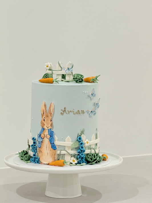Peter Rabbit themed kids birthday cake in powder blue with hand-painted illustration — Bakeology Studios Melbourne