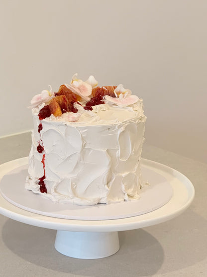 Top view of rustic white buttercream cake with dried fruit and floral topping — Bakeology Studios Melbourne